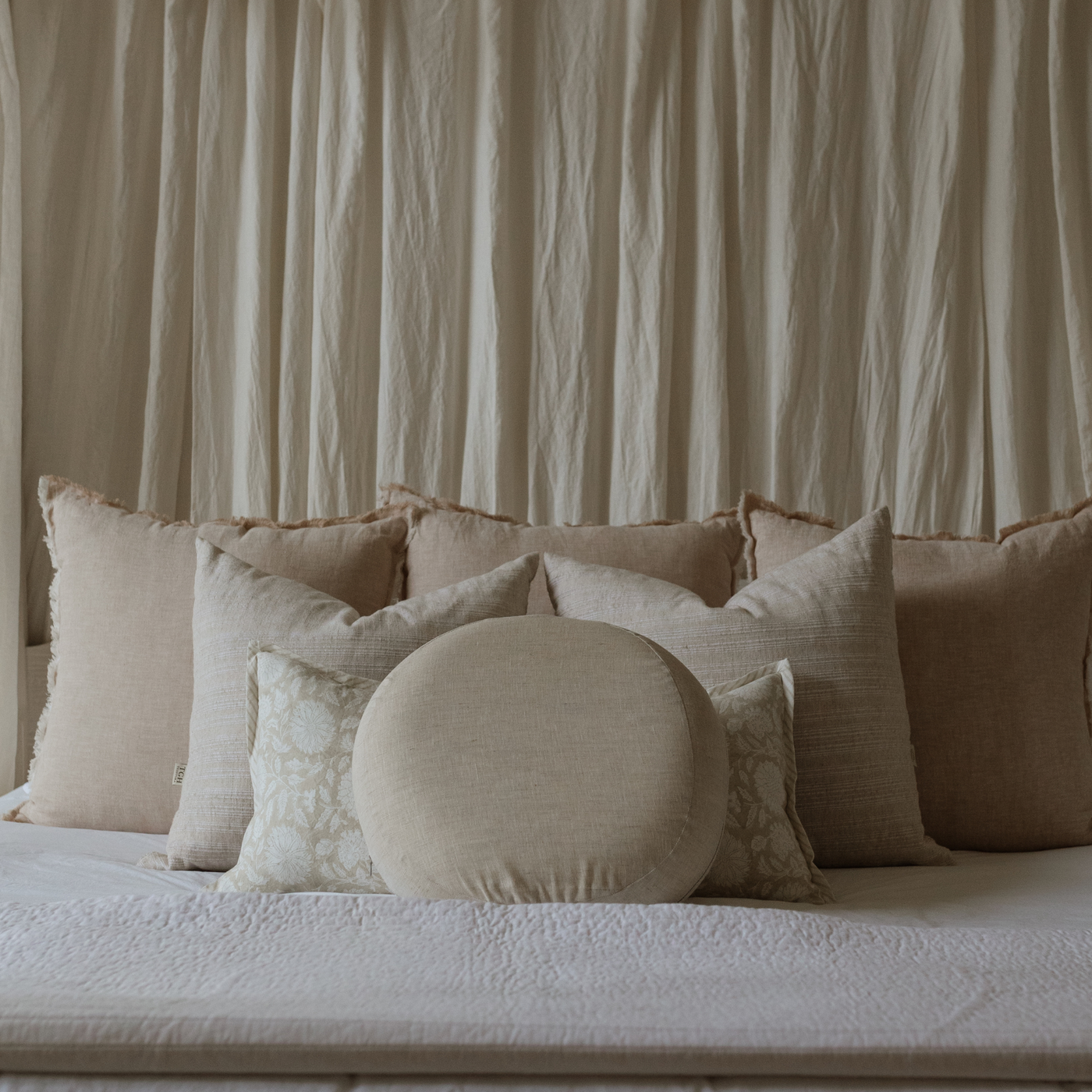 The Prim on a bed with other throw pillows – demonstrating how natural it looks on a bed